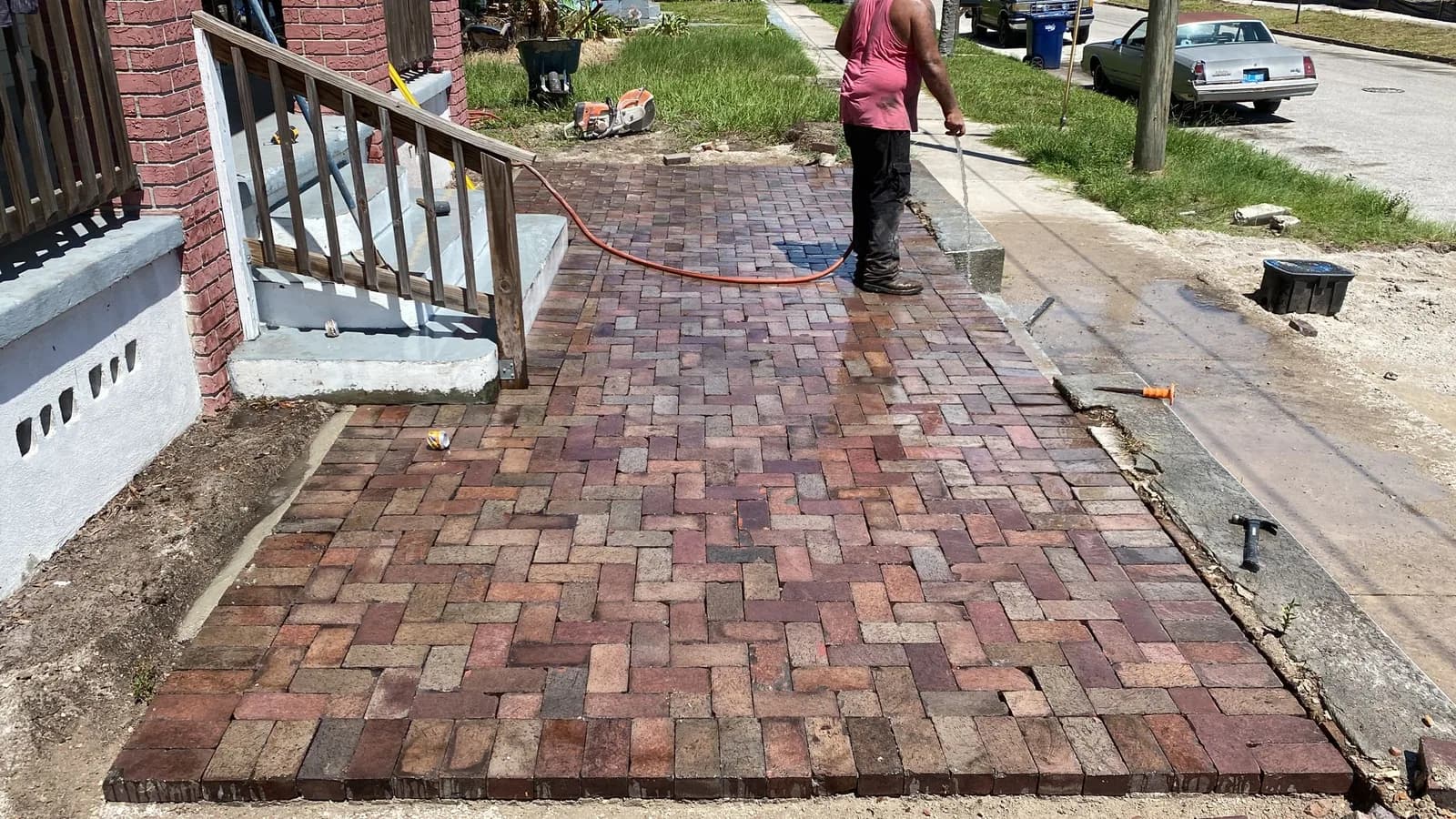 Installer sealing a newly laid brick paver walkway in Florida