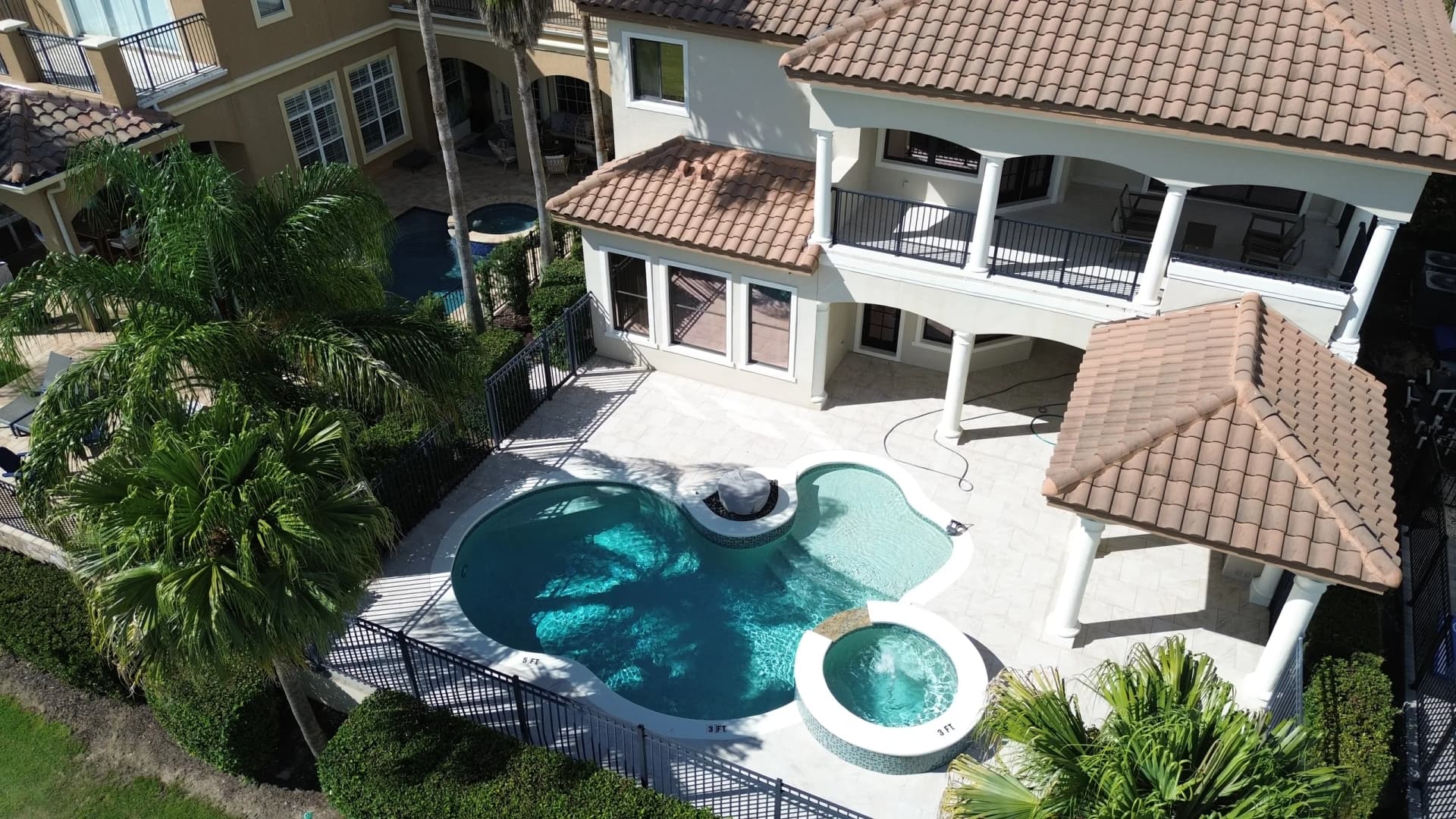 Aerial view of a waterfront pool deck and paver patio installed by EC Paver Solutions in Florida