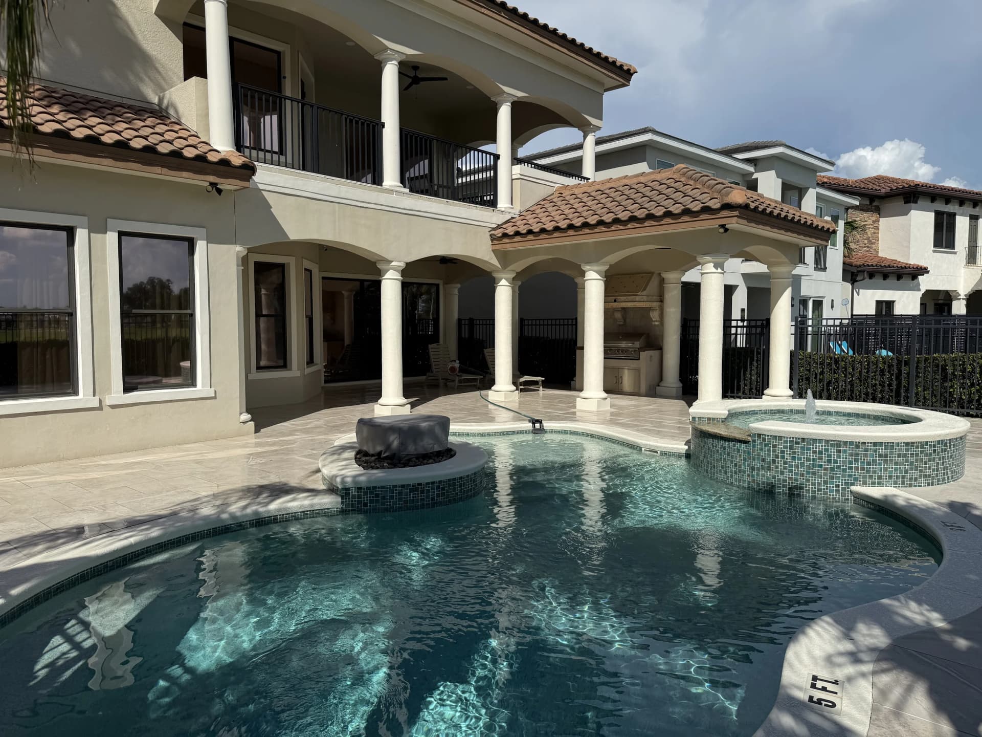 Travertine pool deck with raised spa and spillover, installed by EC Paver Solutions