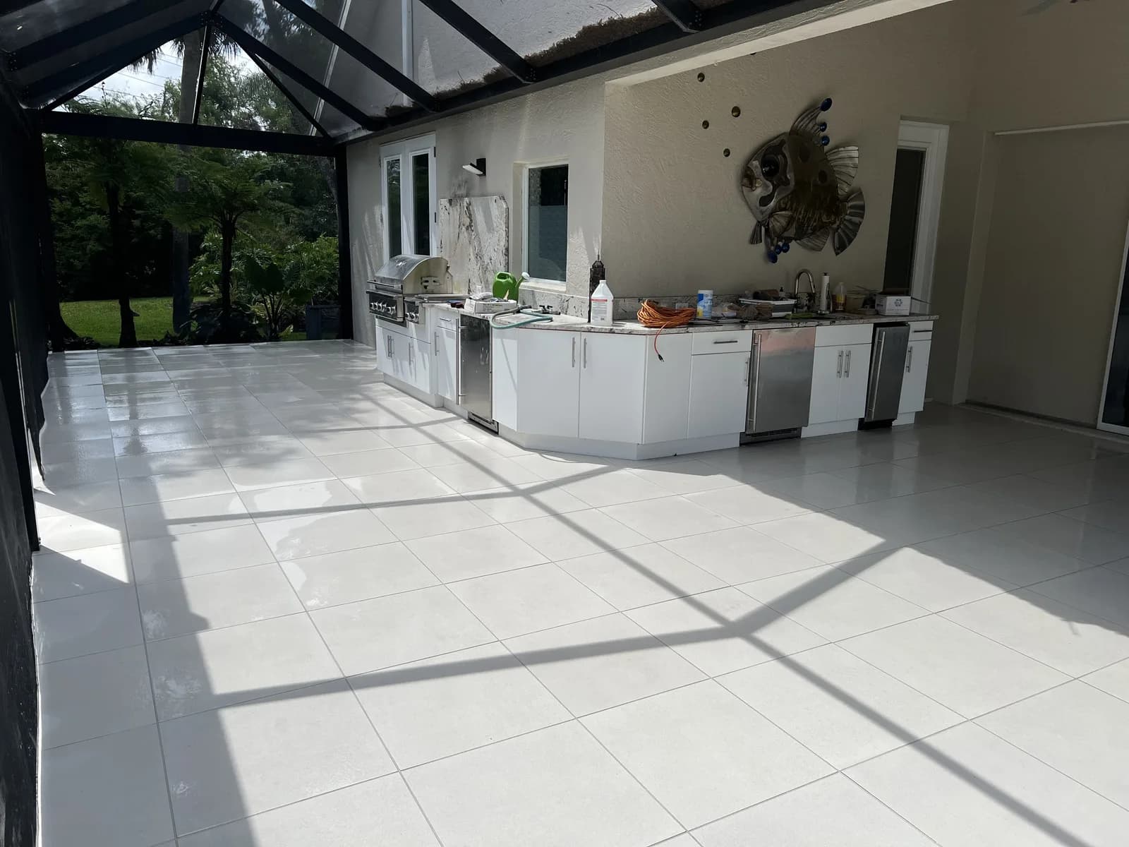 Outdoor kitchen on a paver lanai inside a screened enclosure