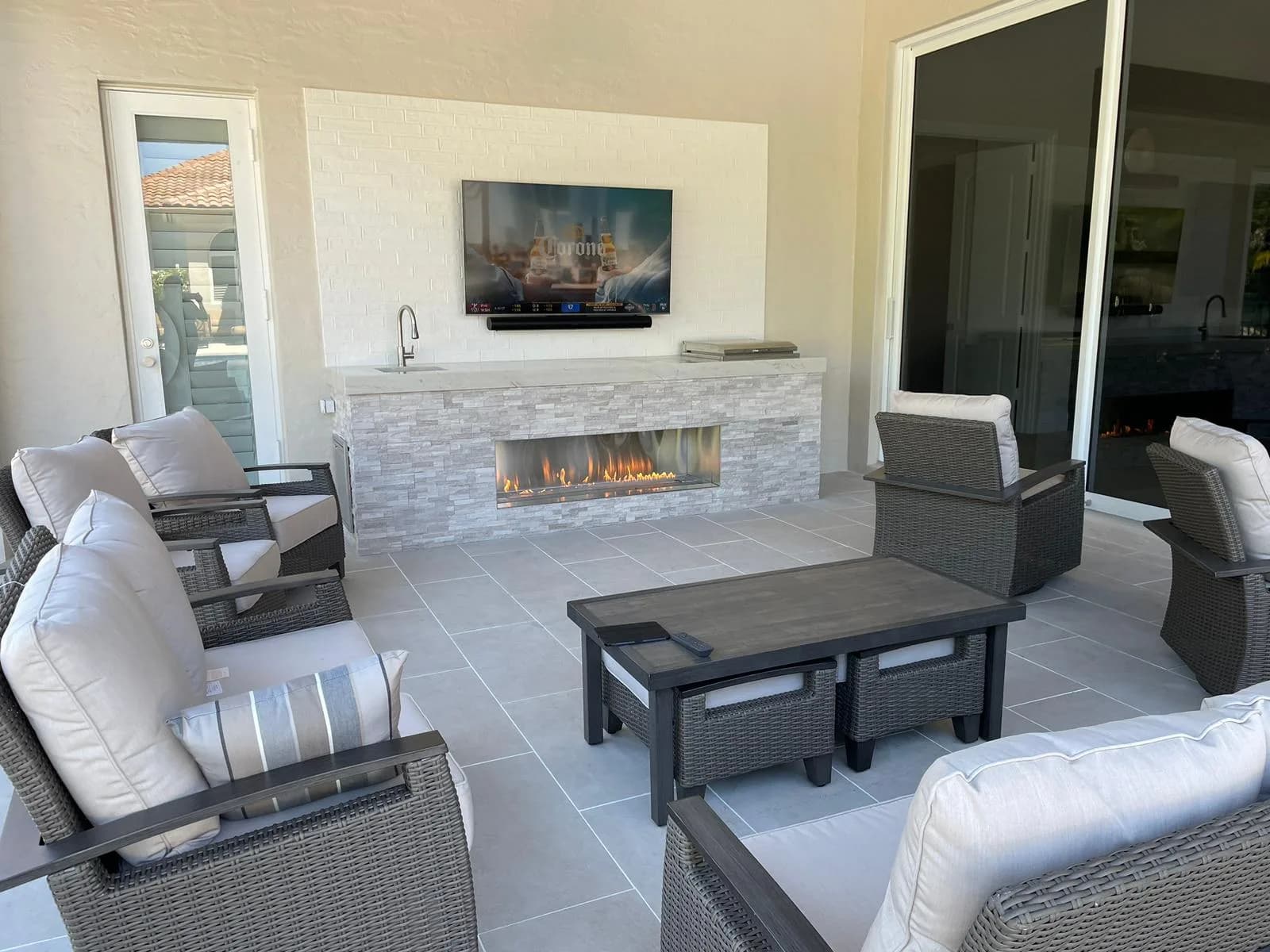 Covered outdoor living room with linear fireplace and porcelain paver flooring