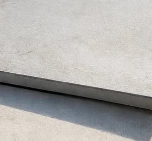 Porcelain paver edge lifting and separating from the bed, indicating hollow spots and bond failure