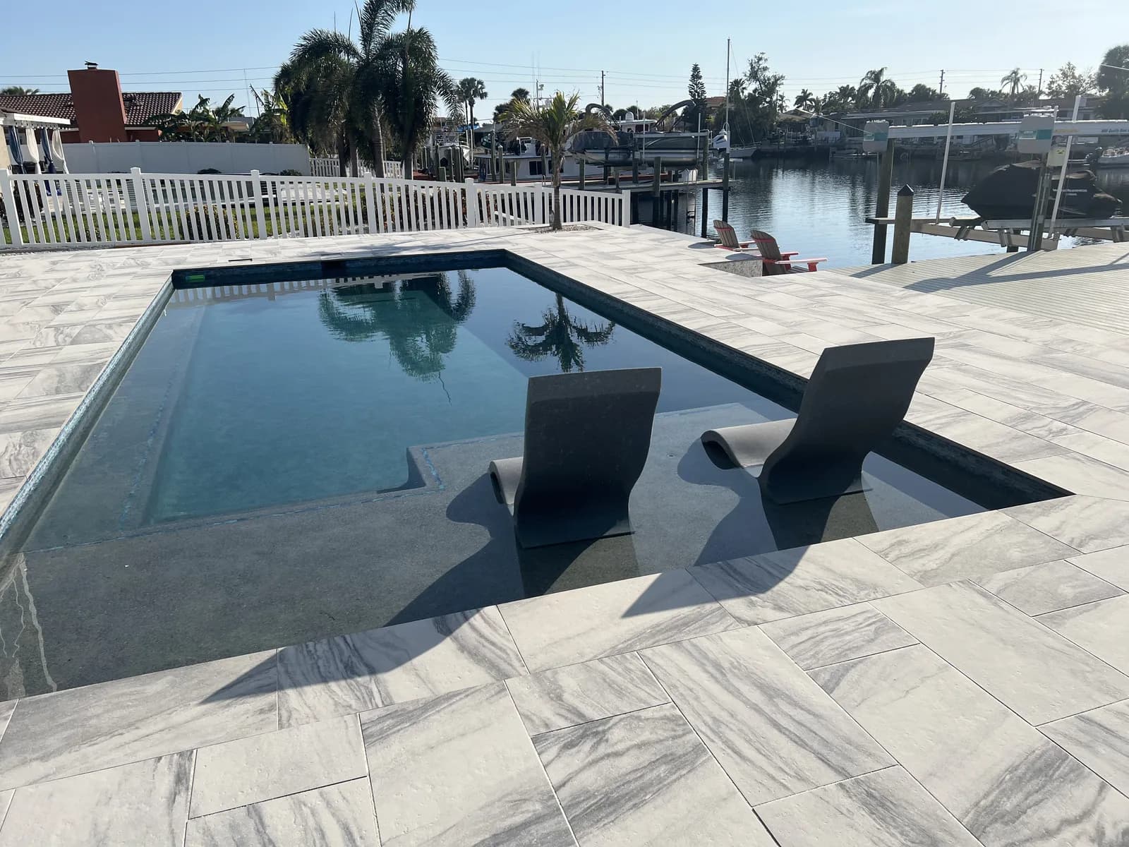 Porcelain paver pool deck facing open water at a waterfront home
