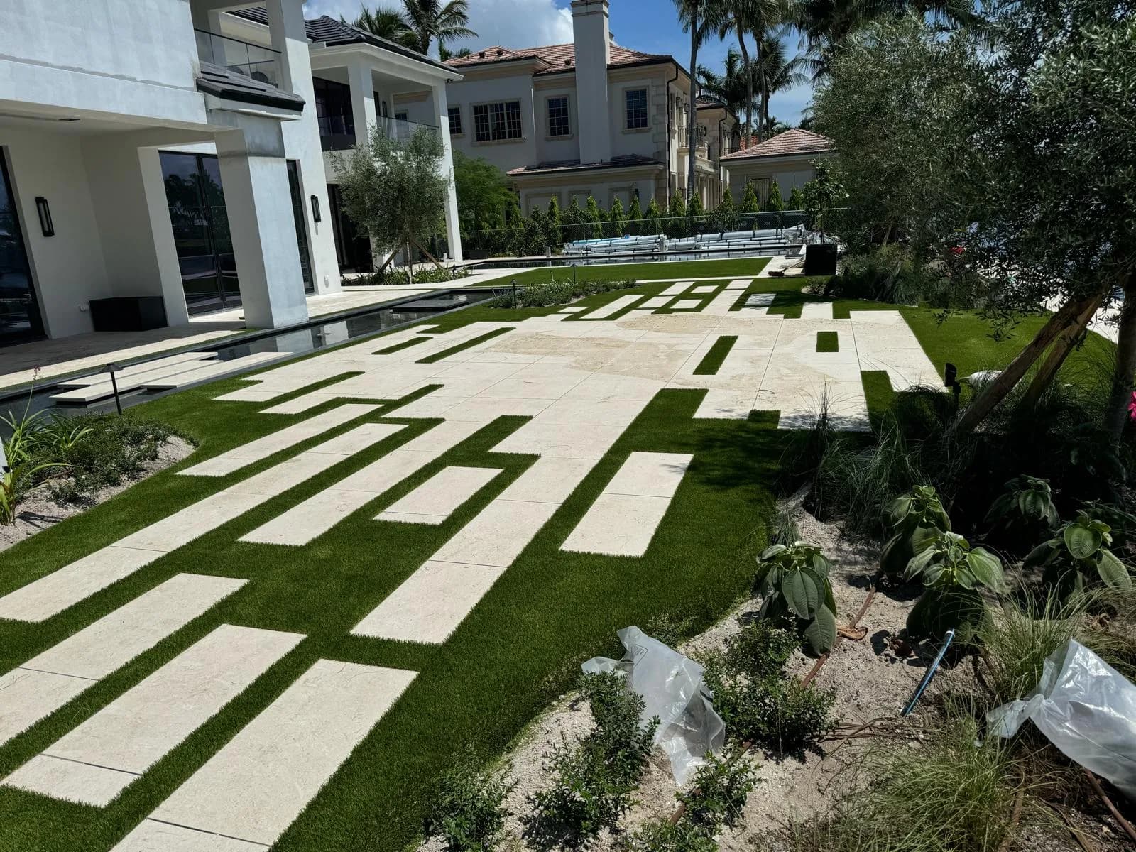 Modern walkway of rectangular pavers set in artificial turf strips